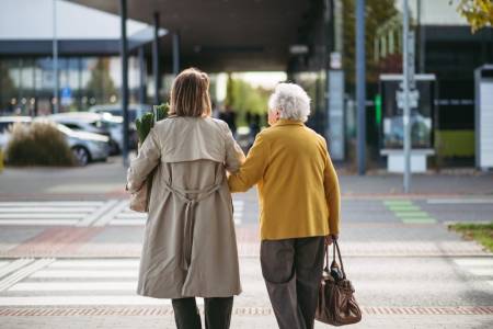 Rear,View,Of,Mature,Granddaughter,Walking,Arm,In,Arm,From