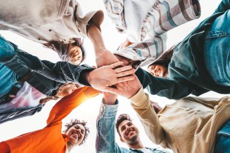 Community,Of,Young,People,Stacking,Hands,Together,-,Multiracial,College